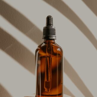 Picture of a brown bottle of oil on a pedestal