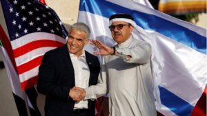 Picture of two leaders shaking hands in front of a flag