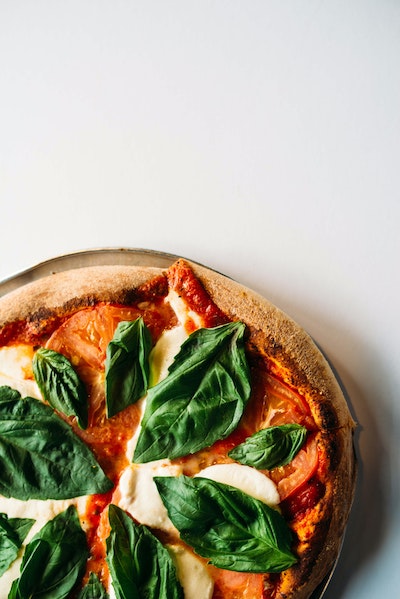 A picture of a pizza with basil.