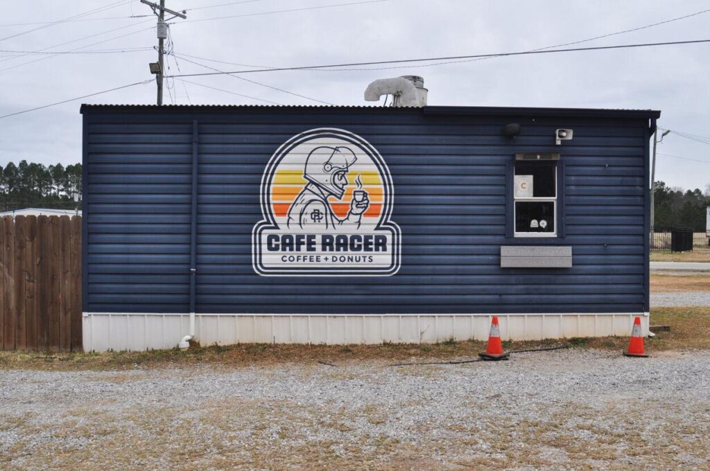 Picture of a blue building with Cafe Racer painted on the side